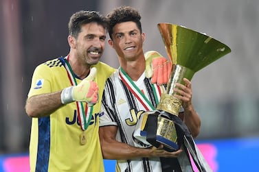 epa08579972 Goalkeeper Gigi Buffon (L) and Cristiano Ronaldo jubilate with the cup during the celebrations for the Juventus' victory of the 9th consecutive Italian championship (scudetto) at Allianz Stadium in Turin, Italy, 01 August 2020. EPA/ALESSANDRO DI MARCO