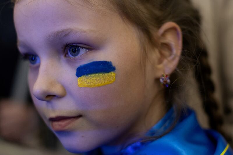 An Ukrainian girl with the national flag painted on her face attends a cultural event in support of the besieged country in a metro station in Dnipro, Ukraine. Reuters