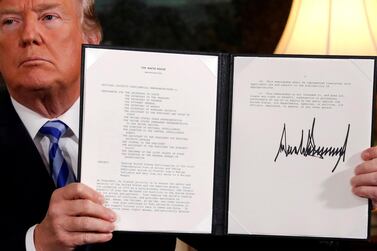 US President Donald Trump holds up a proclamation declaring his intention to withdraw from the Iran nuclear deal in 2018. Reuters