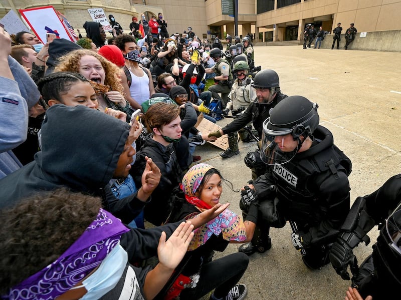 Police officers kneel to the cheers of protesters gathered at Spokane County Courthouse in Spoken, Washington state. AP