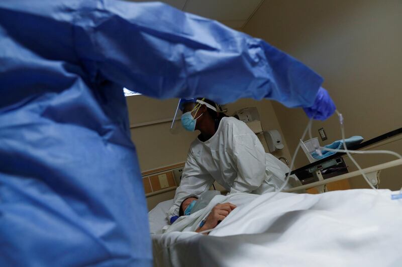 Patient Care Technician Fanta Keita treats a Covid-19 positive patient as she lays on an emergency room bed at Roseland Community Hospital on the South Side of Chicago, Illinois, USA. Reuters