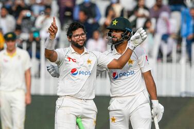 Pakistan's Imam-ul-Haq (L) celebrates after scoring a century (100 runs) with his teammate Abdullah Shafique during the fifth day of the first Test cricket match between Pakistan and Australia at the Rawalpindi Cricket Stadium in Rawalpindi on March 8, 2022.  (Photo by Aamir QURESHI  /  AFP)