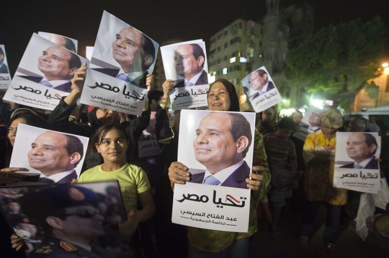 Egyptian supporters of former army chief Abdel Fattah al-Sisi hold his portraits as they watch him on a screen from a street in downtown Cairo, Egypt.  Khaled Desouki / AFP