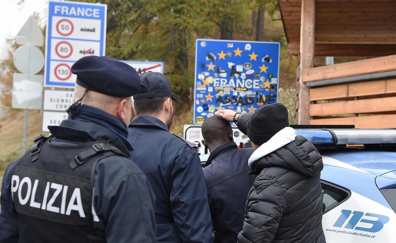 epa07110954 French and Italian policeman check migrants at the border between Italy and France, in Claviere, Italy, 22 October 2018. The conflicts arising from passage of migrants between Italy and France has escalated over the weekend, after French border police turned back migrants trying to enter French soil from the Italian village of Claviere, the border area where now, Italy's interior minister Matteo Salvini has set up a special border patrol.  EPA/ALESSANDRO DI MARCO