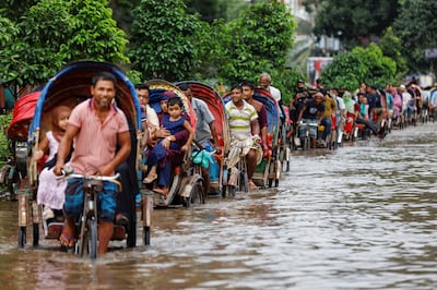 Commuters ride on rickshaws on a flooded road after heavy rains in Dhaka, Bangladesh, in September. Reuters 