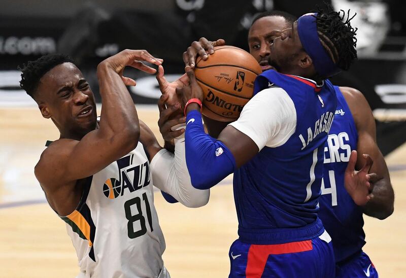 Miye Oni (81) of the Utah Jazz grimaces as he reaches for the ball against Reggie Jackson (1) of the LA Clippers in the fourth quarter of an NBA basketball game in Los Angeles Wednesday, Feb. 17, 2021. (Keith Birmingham/The Orange County Register via AP)