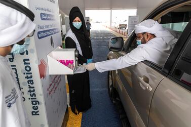 A driver scans his fingerprint as he arrives at a drive-through testing centre in Ras Al Khaimah. Antonie Robertson / The National