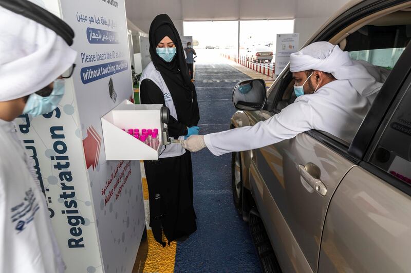 RAS AL KHAIMAH, UNITED ARAB EMIRATES. 12 APRIL 2020. The Ras Ak Khaimah National Screening Center in RAK city that forms part of the drive-through testing centres that opened across the emirates last week. A manuses his Emirates ID card to register before the actual test. (Photo: Antonie Robertson/The National) Journalist: Ruba Haza. Section: National.
