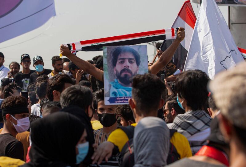 Iraqi demonstrators lift flags as they gather near the local administration building in the southern city of Basra.  AFP