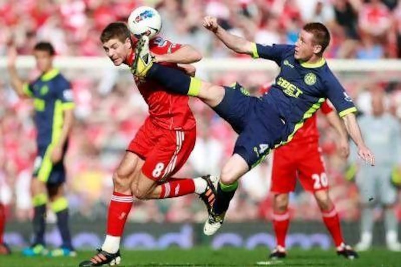 Wigan Athletic's James McCarthy gets a foot past Liverpool's Steven Gerrard, left,