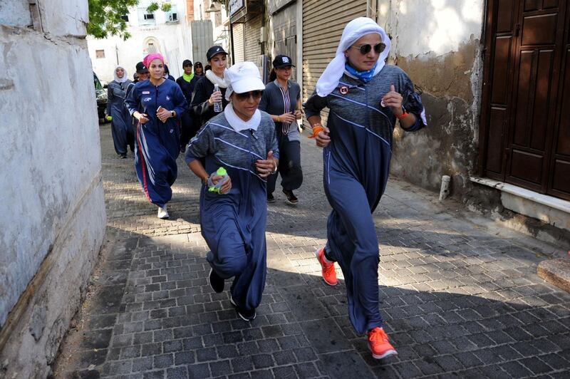 Saudi women jog in the streets of Jeddah's historic al-Balad district on March 8, 2018. / AFP PHOTO / Amer HILABI