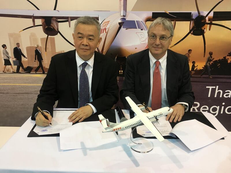 Anawat Leelawatwatana, senior vice-president for finance and accounting at Bangkok Airways, and ATR's Chief Executive Officer Christian Scherer, sign a deal for 4 ATR 72-600s at a ceremony at the Singapore Airshow February 7, 2018.      REUTERS/Brenda Goh
