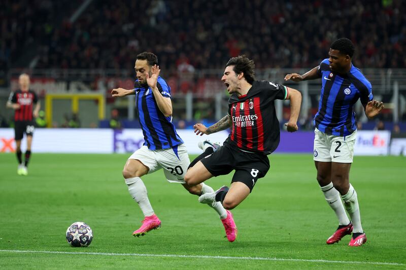 Sandro Tonali of AC Milan is challenged by Hakan Calhanoglu and Denzel Dumfries of Inter. Getty 