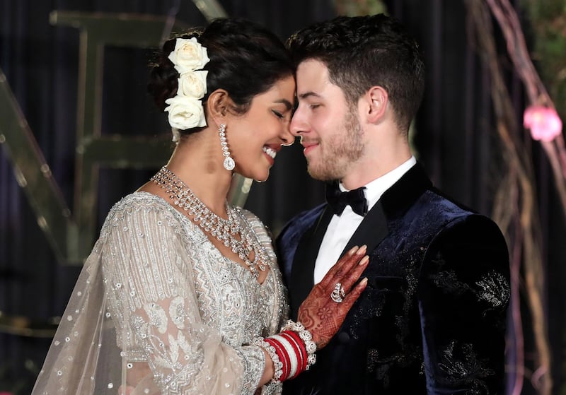 epa07208539 Newlyweds, Bollywood actress Priyanka Chopra (L) and US musician Nick Jonas (R) pose for photographs during a reception in New Delhi, India, 04 December 2018. According to media reports, the couple hosted wedding celebrations in Jodphur on 01 and 02 December.  EPA/RAJAT GUPTA