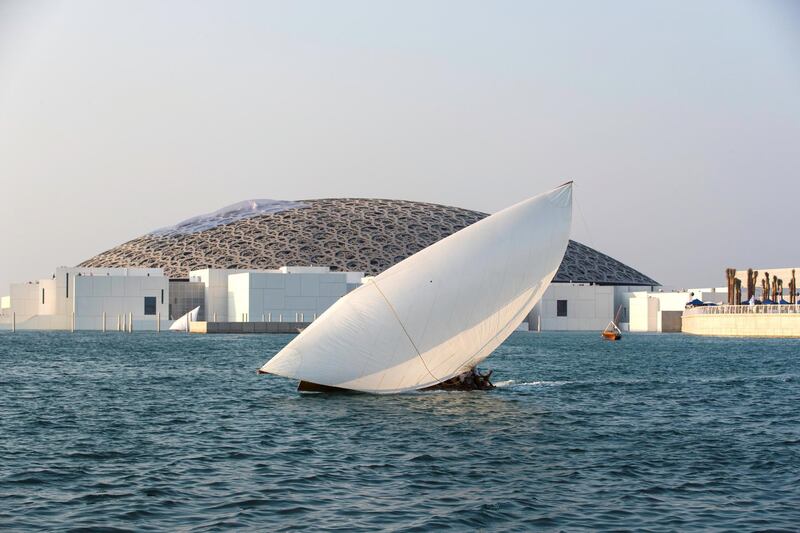 Abu Dhabi, United Arab Emirates, November 11, 2017:    A traditional dhow sails during the past the Louvre Abu Dhabi during the opening day on Saadiyat Island in Abu Dhabi on November 11, 2017. Christopher Pike / The National

Reporter: James Langton, John Dennehy
Section: News