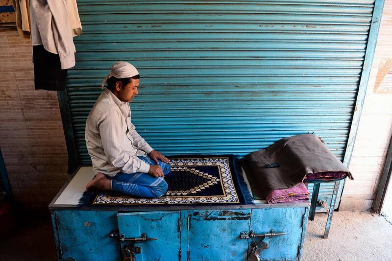 A Muslim man prays in front of closed shops  in New Delhi. AFP