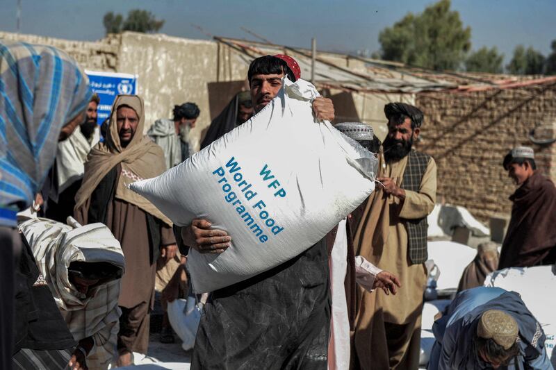 On October 19, 2021 Afghans carry sacks of grains distributed as aid by the World Food Programme in Kandahar, Afghanistan. AFP