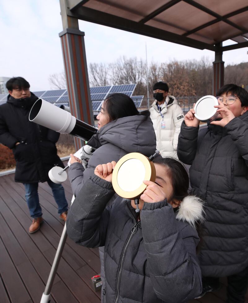 Citizens observe a partial solar eclipse at the Seoul Science Center in Seoul, South Korea.  EPA