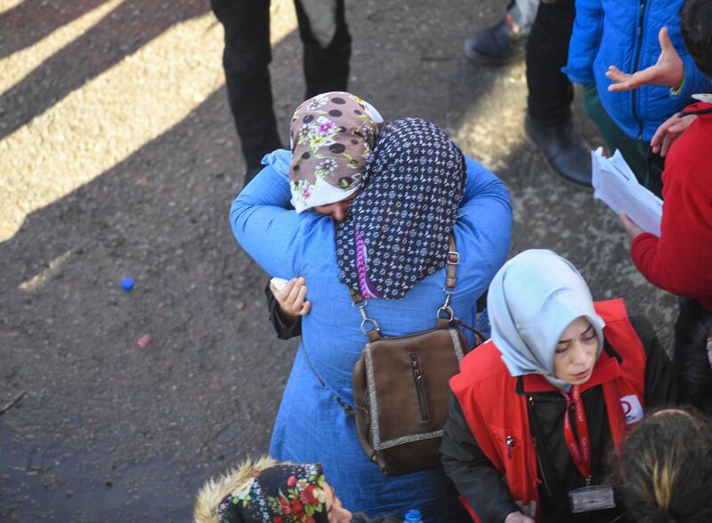 Two women embrace as rescue workers try to save people trapped under debris following a strong earthquake that destroyed several buildings on Friday, in Elazig, eastern Turkey. AP Photo