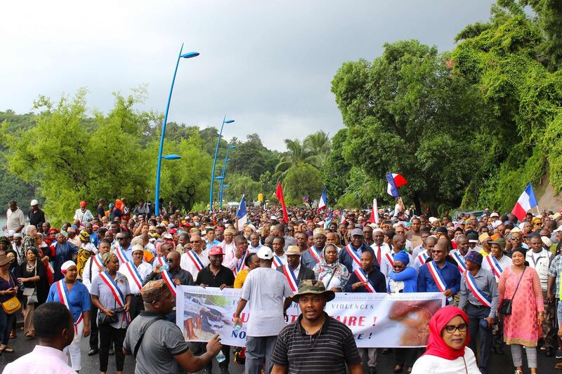 Demonstrators headed by island and city officials march through the streets of Mamoudzou on March 7, 2018 on the French island of Mayotte during a movement called by unions and a collective of the island's associations and dubbed "dead island" protesting insecurity and lack of development on the island. / AFP PHOTO / Ornella LAMBERTI