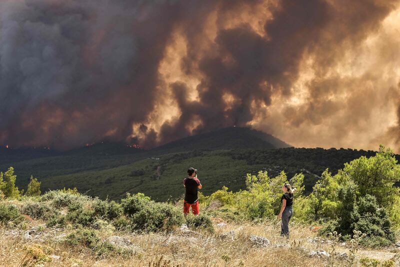 A wildfire approaches the village of Pournari, in Magoula, 25km south-west of the Greek capital, Athens, on July 18. AFP
