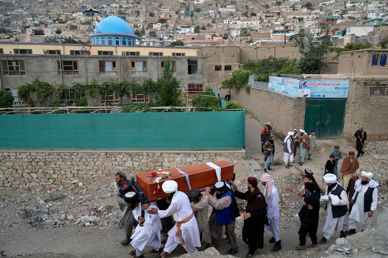 Mourners carry the body of a victim of a mosque bombing in Kabul, Afghanistan. AP