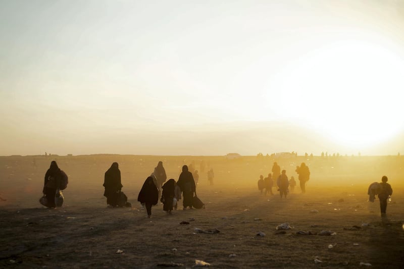Women and children evacuated from the Islamic State (IS) group's embattled holdout of Baghouz arrive at a screening area held by the US-backed Kurdish-led Syrian Democratic Forces (SDF), in the eastern Syrian province of Deir Ezzor, on March 6, 2019. - Veiled women carrying babies and wounded men on crutches hobbled out of the last jihadist village in eastern Syria on March 6 after US-backed forces pummelled the besieged enclave. The Syrian Democratic Forces leading the assault expected more fighters to surrender with their families in tow before moving deeper in the Islamic State group's last redoubt. (Photo by Delil souleiman / AFP)