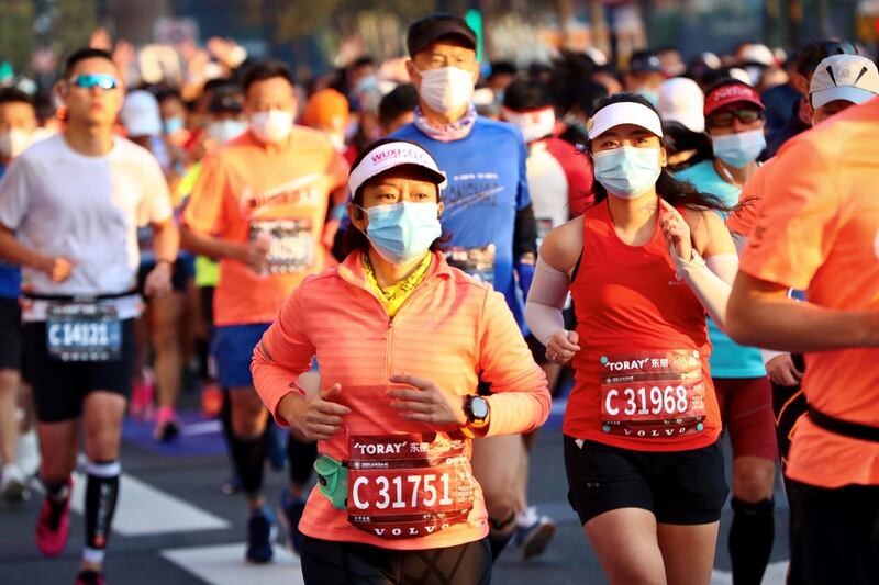 Runners wearing masks take part in the 2020 Shanghai marathon. AFP