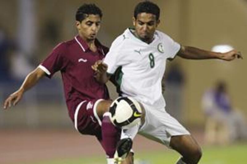Saudi's Abdo Ateef, right, competes with Qatar's Mesaad Al Hamad in Sunday's 0-0 draw.
