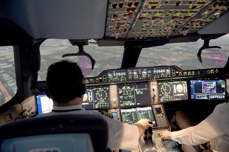 This photograph taken on September 16, 2019, shows Air France pilots inside an Airbus A350 flight simulator at the company training centre near Roissy Charles de Gaulle airport, north-east of the French capital Paris. - "Ready for take off?" "Take off!" The A350 launches onto the runway, takes off, before a "reactor pumping" phenomenon disrupts the well-oiled mechanics: we are in a simulator where Air France pilots put their skills to the test. "The simulator is a central tool in pilot training, at the heart of the training and safety issues," explains Eric Prévot, captain on the Boeing 777 at Air France and spokesman for the company's flight operations. (Photo by ERIC PIERMONT / AFP)