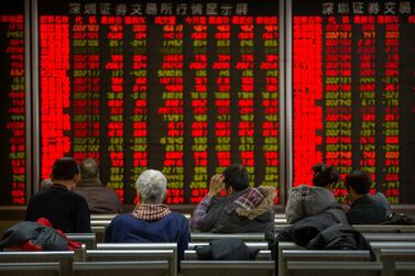 Chinese investors monitor stock prices at a brokerage house in Bejiing on Thursday. AP