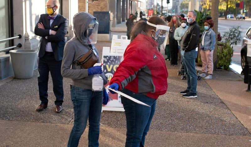 Poll workers disinfect each other other after a voter with coronavirus disease dropped off her ballot curbside to prevent the spread of the virus in St. Louis, Missouri, US. Reuters