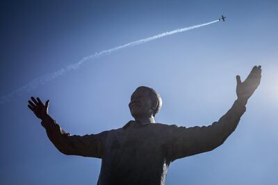 A South African airforce jet flies over a statue of Nelson Mandela at the Union Building in Pretoria during the celebrations of the 20th anniversary of Freedom day, which marks the end of the Apartheid politic, in Pretoria on April 27, 2014.    AFP PHOTO / FEDERICO SCOPPA (Photo by FEDERICO SCOPPA / AFP)
