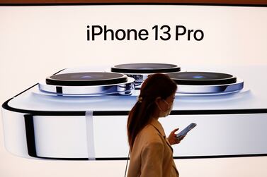 FILE PHOTO: A woman wearing a face mask walks past an image of an iPhone 13 Pro at an Apple Store in Beijing, China, September 24, 2021.  REUTERS / Carlos Garcia Rawlins / File Photo