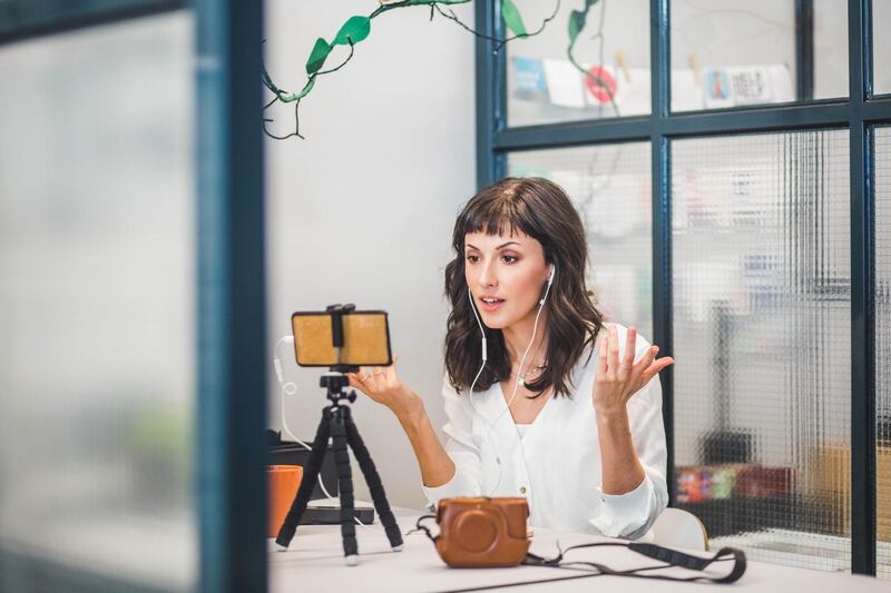 Creative businesswoman attending video conference through mobile phone at desk in office. Getty Images