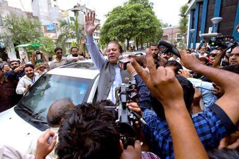 Former Prime Minister and leader of the Pakistan Muslim League, Nawaz Sharif, center, waves to his supporters as he leaves a polling station after casting his vote in Lahore, Pakistan, Saturday, May 11, 2013. Defying the danger of militant attacks, Pakistanis streamed to the polls Saturday for a historic vote pitting a former cricket star against a two-time prime minister and an unpopular incumbent. But attacks that killed several people and wounded dozens more underlined the risks many people took just casting their ballots. (AP Photo/Anjum Naveed) *** Local Caption *** Pakistan Election .JPEG-0ed8e.jpg