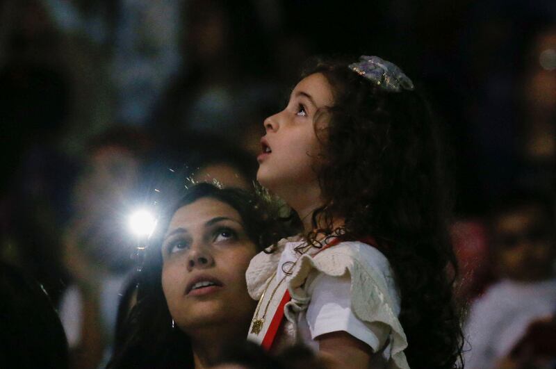 An Egyptian Coptic Orthodox Christian girl attends the Easter midnight mass with her mother. Reuters