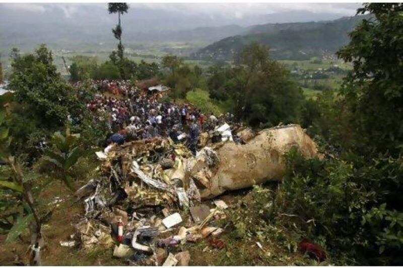 Rescue workers and civilians gather around the wreckage of a Beechcraft 1900D operated by Buddha Air after it crashed in the mountains outside Bisankunarayan village, just south of Kathmandu, Nepal, early yesterday. Niranjan Shrestha / AP Photo