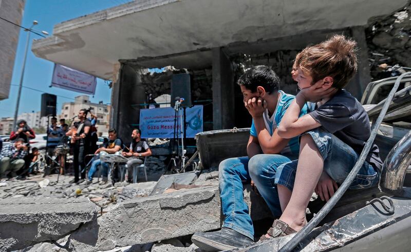 Palestinian boys listen to members of the band Dawaween performing during a musical event calling for a boycott of the Eurovision Song Contest. AFP