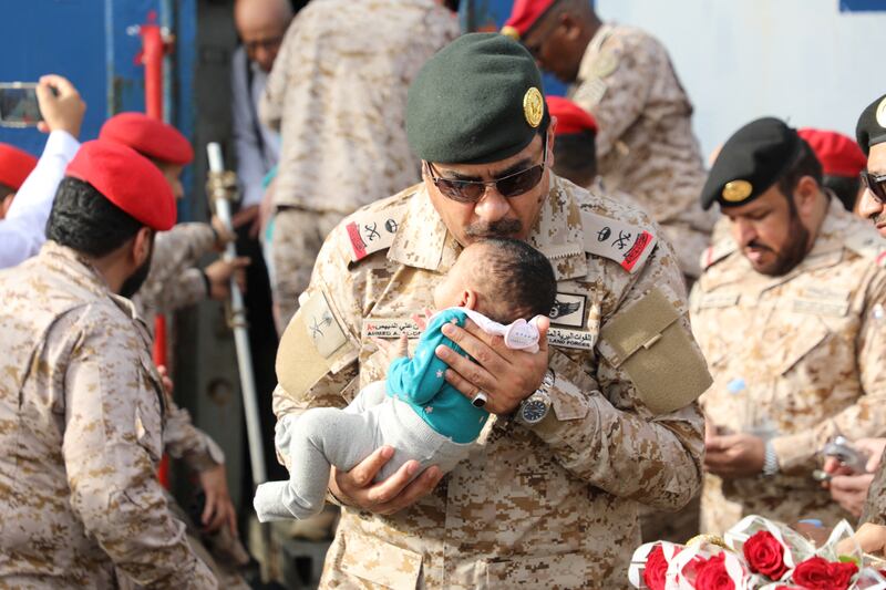 Saudi Navy personnel assist a child being evacuated by Saudi Arabia from Sudan to escape the conflicts, at Jeddah Sea Port, Jeddah, Saudi Arabia, April 26, 2023.  Saudi Ministry of Defense / Handout via REUTERS ATTENTION EDITORS - THIS PICTURE WAS PROVIDED BY A THIRD PARTY