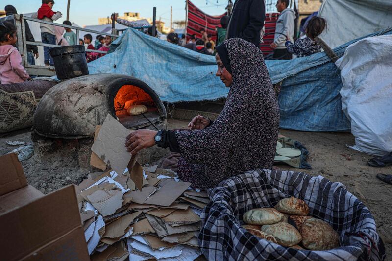 A displaced Palestinian woman bakes bread before an iftar meal, in the southern Gaza Strip. AFP