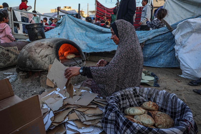 A displaced Palestinian woman bakes bread for iftar in Rafah. AFP