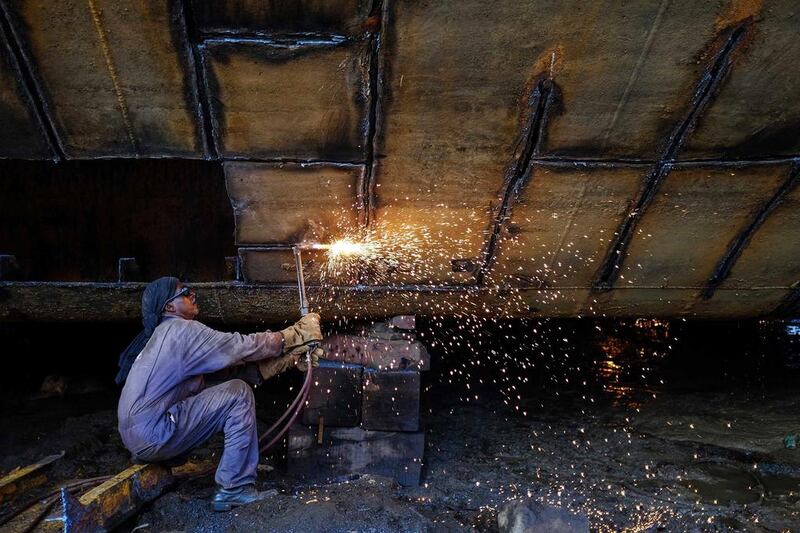 A worker repairs a vessel at a ship repair yard in Mumbai. India’s factory growth showed no sign of acceleration in April 2014 as tepid demand restrained output even as price pressures eased. Danish Siddiqui / Reuters