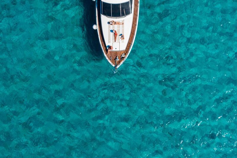 An aerial view shows people sunbathing on a yacht off the small island of Chrysi, south of Crete.  AFP