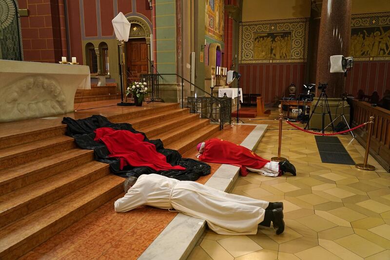 Berlin Archbishop Heiner Koch and Monsignor Hansjoerg Guenther prostrate themselves while rehearsing the veneration of the cross for the Good Friday liturgy that will be broadcast live from Saint Joseph Church. Getty Images