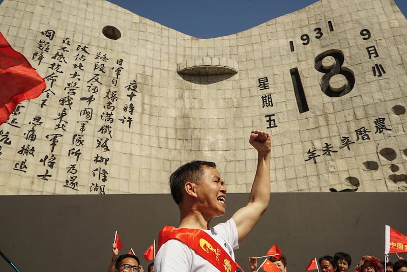 A man makes a vow in front of a memorial of the September 18th History Museum to commemorate the 87th anniversary of the "September 18 incident" in Shenyang in China's northeastern Liaoning province. AFP