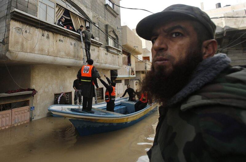 Members of the Palestinian civil defence ride a boat down a flooded street. The downpour that began late Wednesday was part of a storm that covered parts of Israel and the West Bank with snow, paralysed Jerusalem and left thousands in Israel without power. Mohammed Salem / Reuters