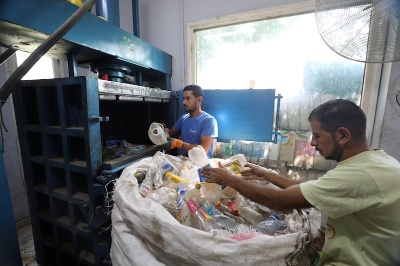 Volunteers sort plastic at a community-owned recycling unit, with some bottles to be used for the pyramid project in Giza.