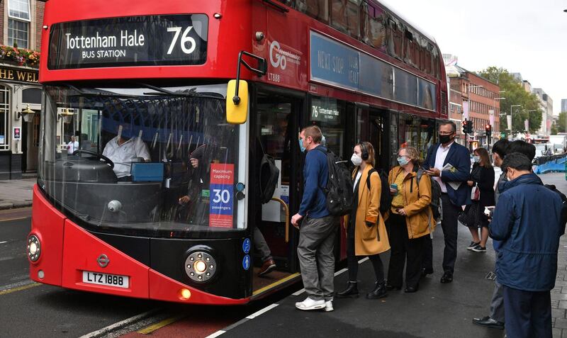 People board a bus outside Waterloo station in London. AP Photo