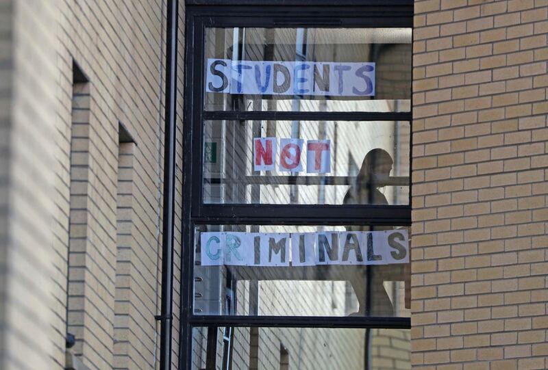A student walks past a sign at Murano Street Student Village in Glasgow. AP Photo
